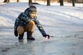 A boy launches a paper boat in the spring creek Royalty Free Stock Photo