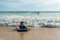 A boy lay down on body board while the wave move to the beach. Royalty Free Stock Photo