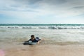 A boy lay down on body board while the wave move to the beach. Royalty Free Stock Photo