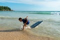 A boy lay down on body board while the wave move to the beach. Royalty Free Stock Photo