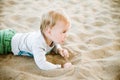 The boy is laying on the beach