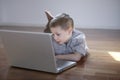 Boy laying down on the floor with laptop computer Royalty Free Stock Photo