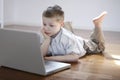 Boy laying down on the floor with laptop computer Royalty Free Stock Photo