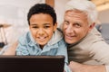 Boy laying at the floor and using tablet while relaxing with his grandfather Royalty Free Stock Photo