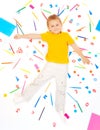 Boy laying among office supply objects collection