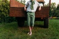 The boy is leaning on the old truck cousin, barefoot on the grass in the summer. hands in pockets Royalty Free Stock Photo