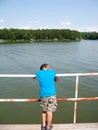 Boy leaning on railing by lake Royalty Free Stock Photo