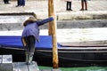 A boy leaning towards a gondola near Grand Canal in Venice, Italy. Royalty Free Stock Photo