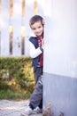 A boy leaning on a wall, smiling