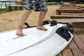 Boy learn to stand on the surf on the beach on the shore of the lake, sea, water sports, active lifestyle, vacation, heat Royalty Free Stock Photo