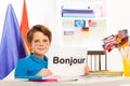 Boy learning French sitting at desk in classroom