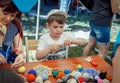 Boy learning to make colorful table napkins at knitting workshop