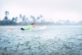 Boy learning to surf under the tropical rain Royalty Free Stock Photo