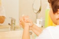 Boy learning to wash hands with soap and water