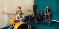 Boy learns to play the drum kit. Music lesson with teacher.