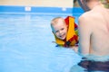 Boy learns to swim in pool with father Royalty Free Stock Photo