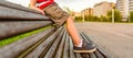 Boy legs sitting on the top of bench park relaxing