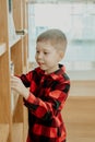 Boy in the library chooses a book. Happy child at the shelf with books. Royalty Free Stock Photo