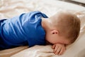 The boy lies on the bed with his back turned and cries Royalty Free Stock Photo