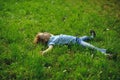 The boy lies in a dense green grass on lawn. Royalty Free Stock Photo