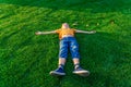 The boy lies on the green grass and looks to the sky Royalty Free Stock Photo