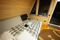 Boy lies and rests on the bed in cozy wooden tiny cabin house. Life in countryside Royalty Free Stock Photo