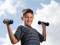 Boy lifting dumbbells outdoors Royalty Free Stock Photo