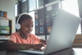 Boy listening music while using laptop Royalty Free Stock Photo