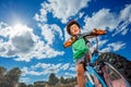 Boy on little bicycle riding at park portrait over sky