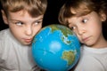 Boy and little girl steadfastly looking at globe Royalty Free Stock Photo