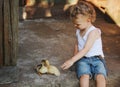 Boy with little yellow duckling in summer village Royalty Free Stock Photo