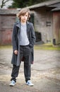 Boy in Long Coat Standing in a Farm Yard Royalty Free Stock Photo