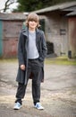 Boy in Long Coat Standing in a Farm Yard Royalty Free Stock Photo