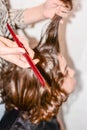 Boy with long hair gets his hair cut by hairdresser