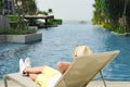 Boy on the longue chair near the swimming pool relaxing. Travel concept, travelling, hotel business.