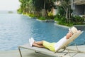 Boy on the longue chair near the swimming pool relaxing. Travel concept, travelling, hotel business