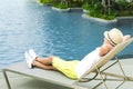 Boy on the longue chair near the swimming pool relaxing. Travel concept, travelling, hotel business