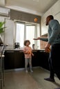 Boy look at father juggle with oranges at kitchen Royalty Free Stock Photo