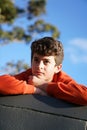 Boy looking ahead while resting on top of wall. Royalty Free Stock Photo