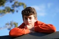 Boy looking ahead while resting on top of wall. Royalty Free Stock Photo