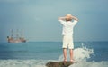 Boy looking on big old ship on the sea Royalty Free Stock Photo