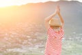 Boy looking at the city from a height. Hands over head. Rear view, sunset time Royalty Free Stock Photo