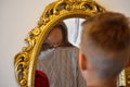 The child reflected in a distorting mirror. A fun reflection of the boy. Children`s entertainment