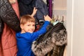 The boy is looking for his winter things in his home wardrobe before going outside Royalty Free Stock Photo