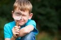 Boy Looking Through Magnifying Glass With Magnified Eye