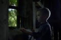 A boy looking out the window in the old house. Royalty Free Stock Photo