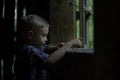 A boy looking out the window in the old house. Royalty Free Stock Photo