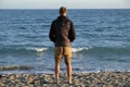 A boy looking panorama over the sea horizon in the beach - winter season at sunset