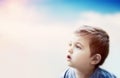 Boy looking at the sky with surprised expression. Child imagination