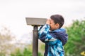 Boy looking in telescope in park. Tourists on observation deck Royalty Free Stock Photo